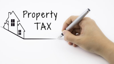 Image of Hand drawing a house with the words Property Tax beside it