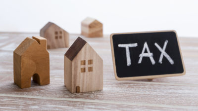 Image showing model wooden houses with a blackboard with the words Tax written on it depicting LBTT